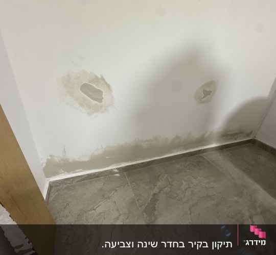 קיר עם סימני רטיבות ותיקונים